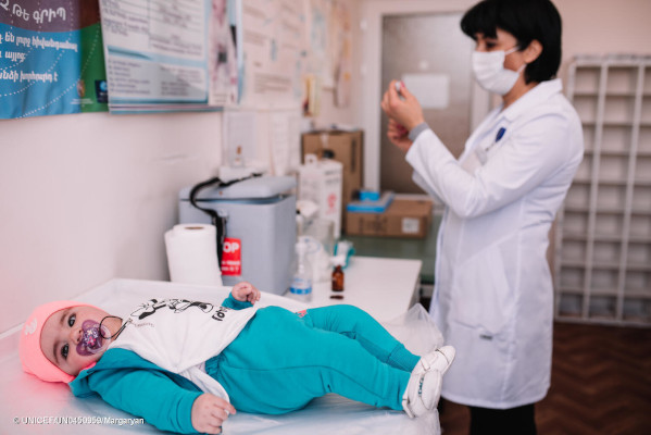 The little girl is waiting to receive her routine vaccination. at polyclinic #1 in Vanadzor. April 21, 2021 Vanadzor, Lori region, Armenia Children receiving their routine vaccination in UNICEF-supported polyclinic #1 in Vanadzor, amidst the COVID-19 pandemic in Armenia. UNICEF supported this and other healthcare institutions in the country with training for healthcare workers on COVID-19 related issues. For over two decades UNICEF supported Ministry of Health in Armenia to deliver routine immunization vaccines and to ensure proper cold-chain system.